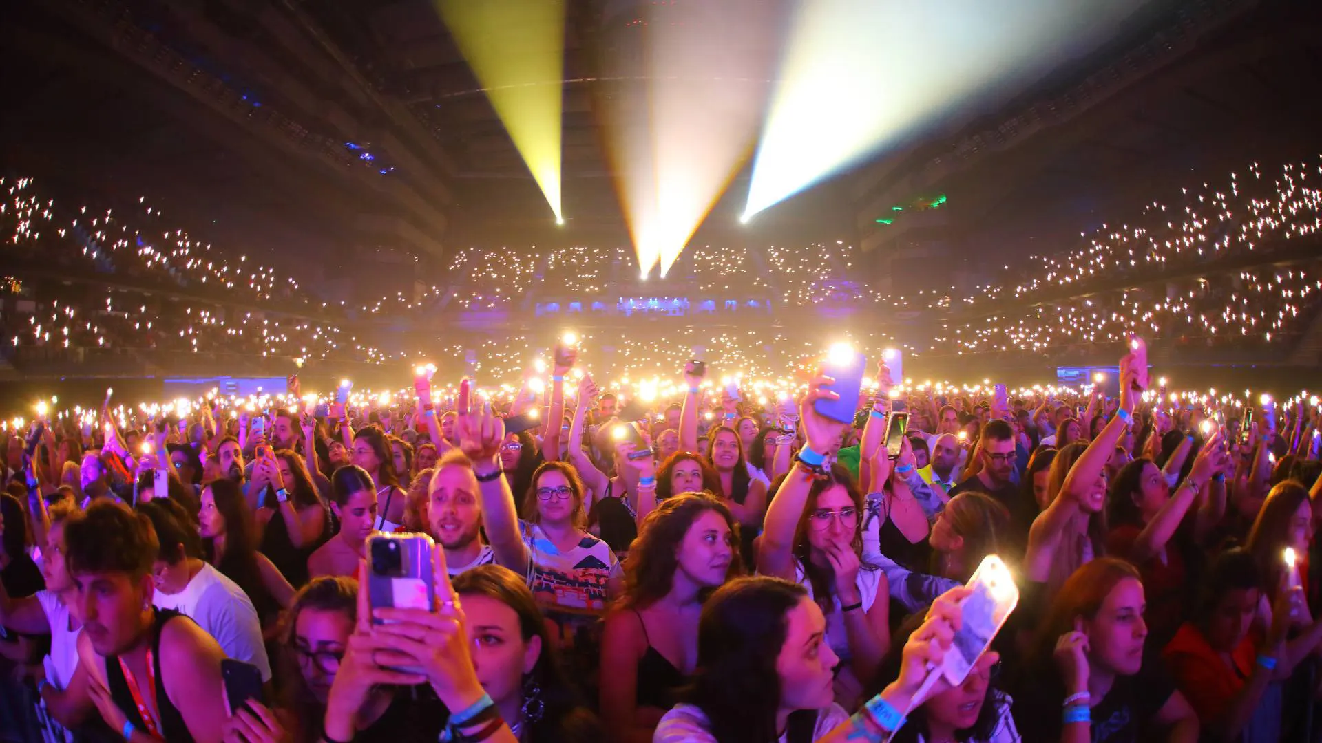 Interior del WiZink Center durante un concierto multitudinario con móviles iluminados